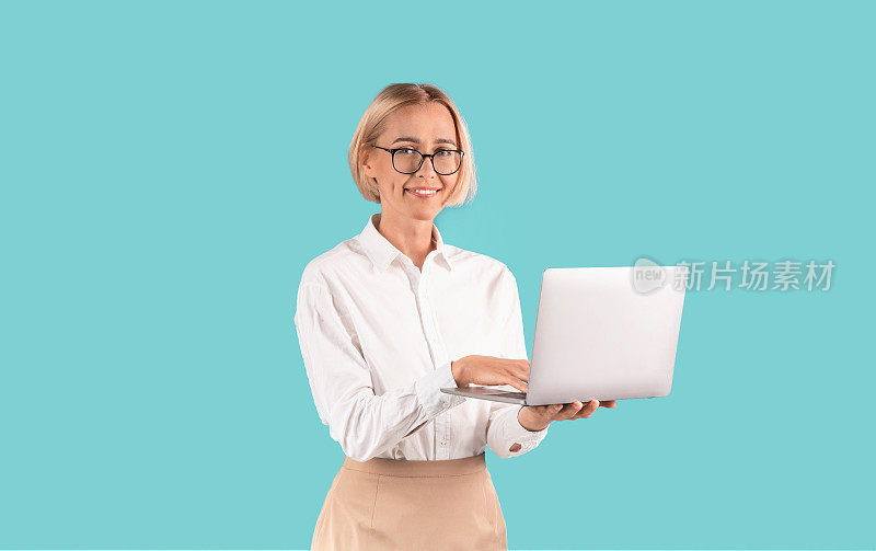 Confident business lady with laptop smiling against blue background